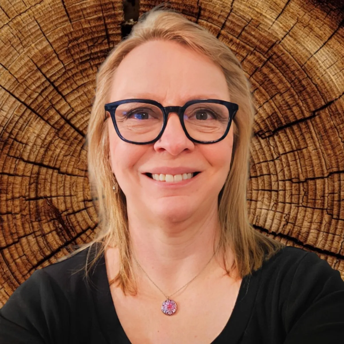 Smiling woman in front of a wooden backdrop, showcasing transformation with Slender Spirit’s wellness program.