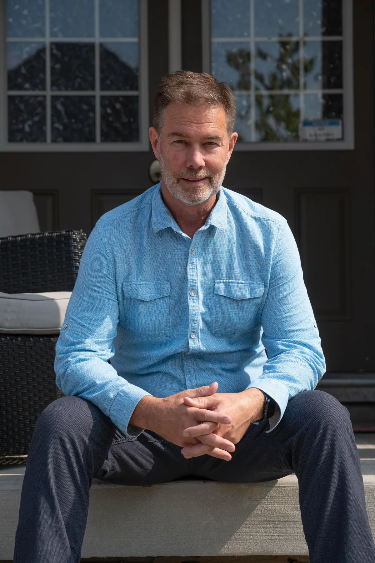 a man leaning against a wall with his arms crossed