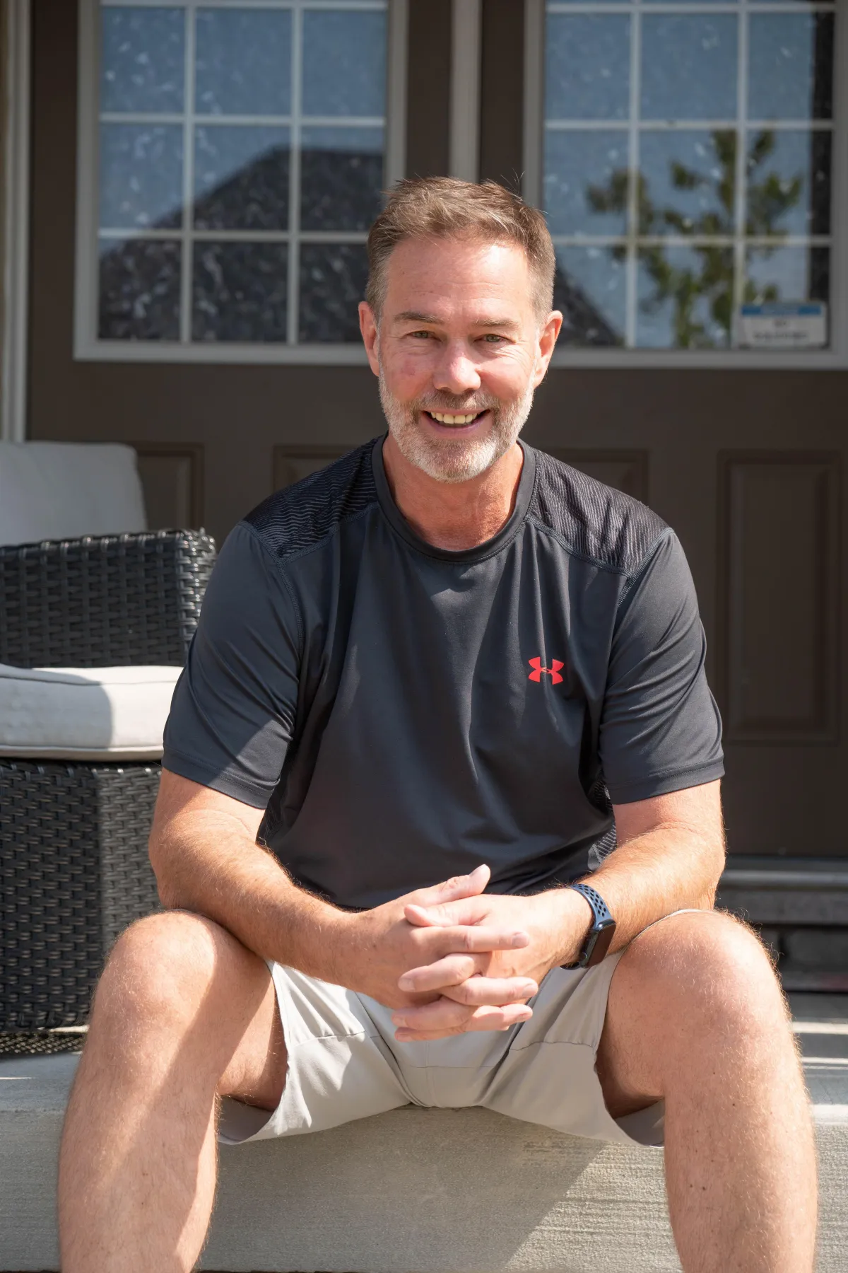 a man sitting on the ground in front of a building