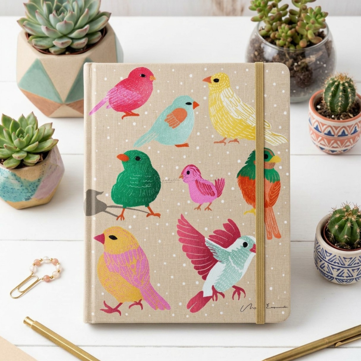 Closed journal with the Flock Together bird illustration cover design, shown on a table.