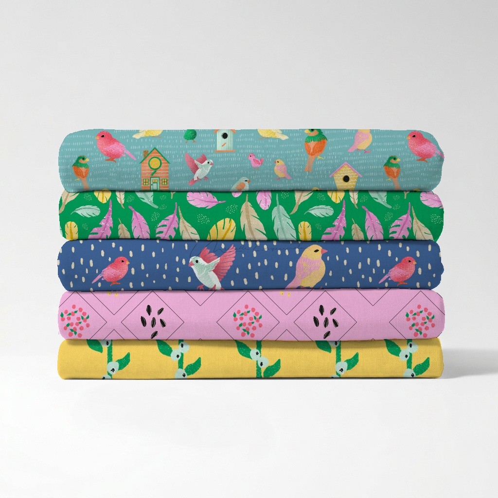 Stack of folded fabric swatches showing five repeat bird patterns from the Birds of a Feather surface pattern collection.