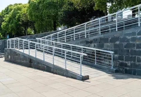 Concrete accessibility ramp with metal railings built on a sloped walkway – Gresham Concrete Services.