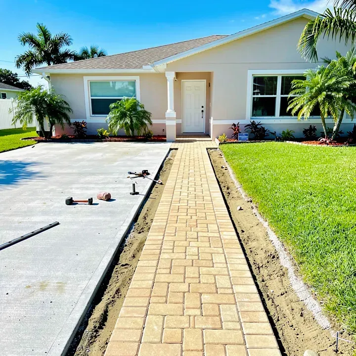 Paver sidewalk installation in progress connecting a driveway to an entrance in Kendale Lakes, Florida