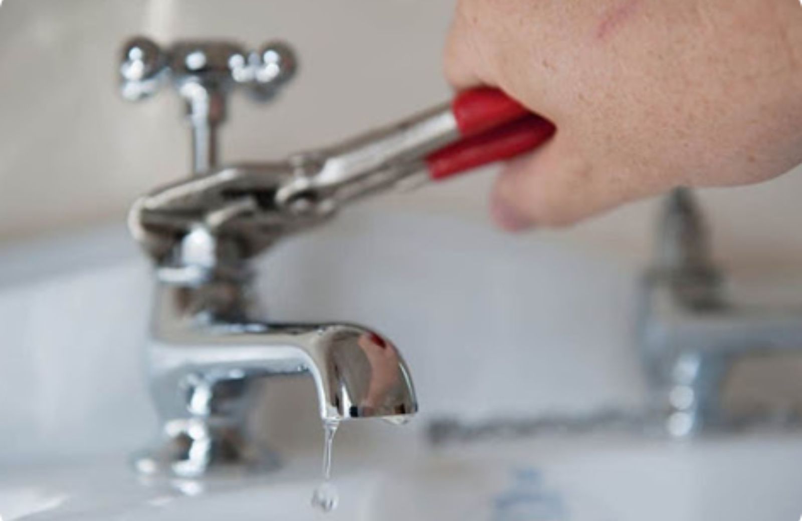 Houston residential plumbing repair – plumber using a wrench to fix a bathtub faucet in a Houston home