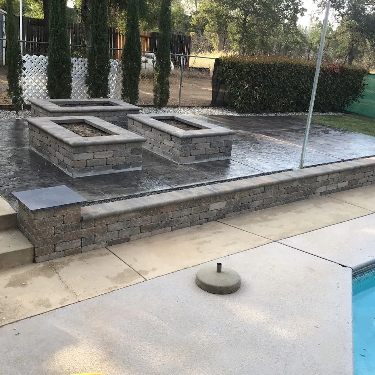 Stamped concrete patio in Redding, CA with raised seating walls and fire feature area