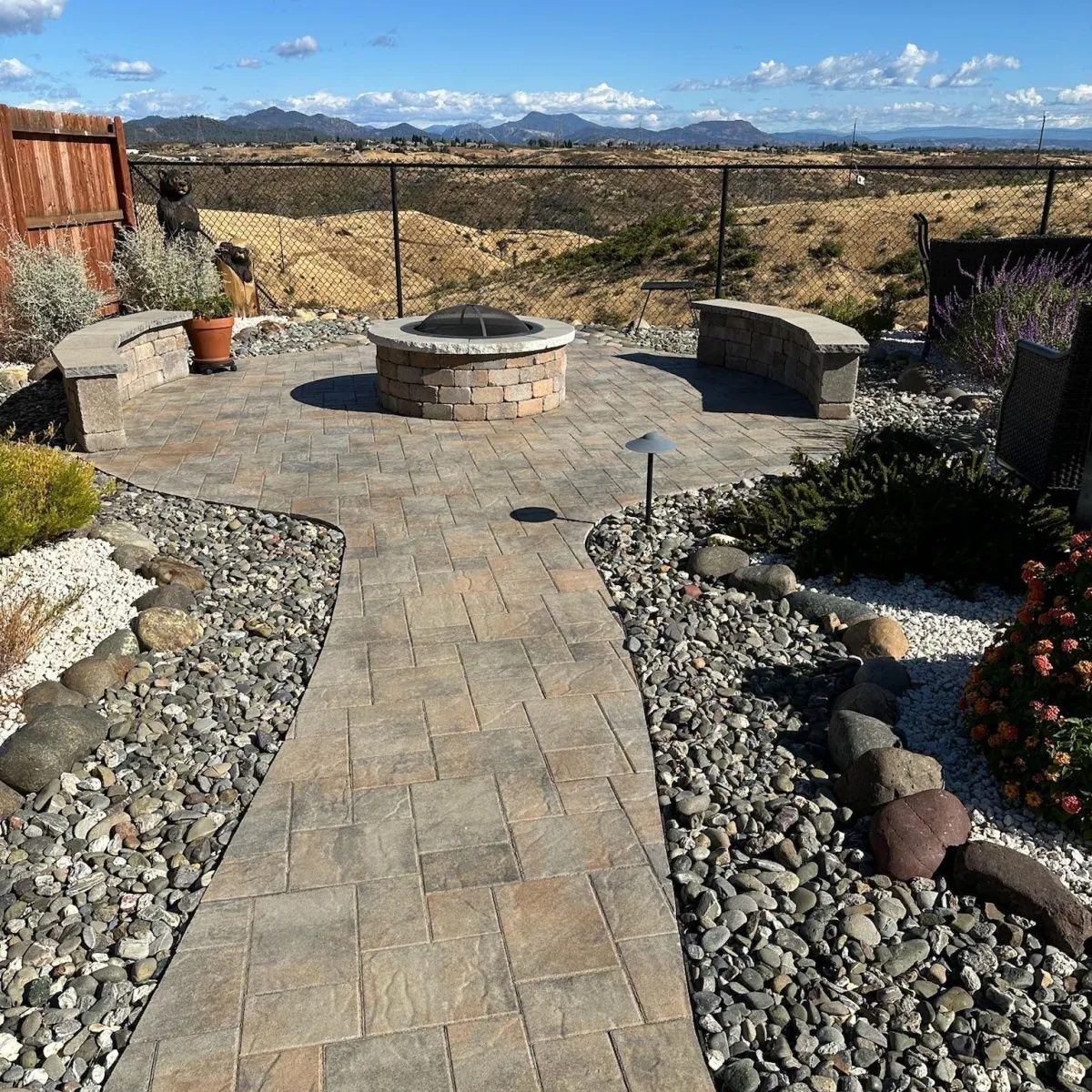 Decorative concrete walkway and patio in Redding, CA with fire pit seating area and rock borders