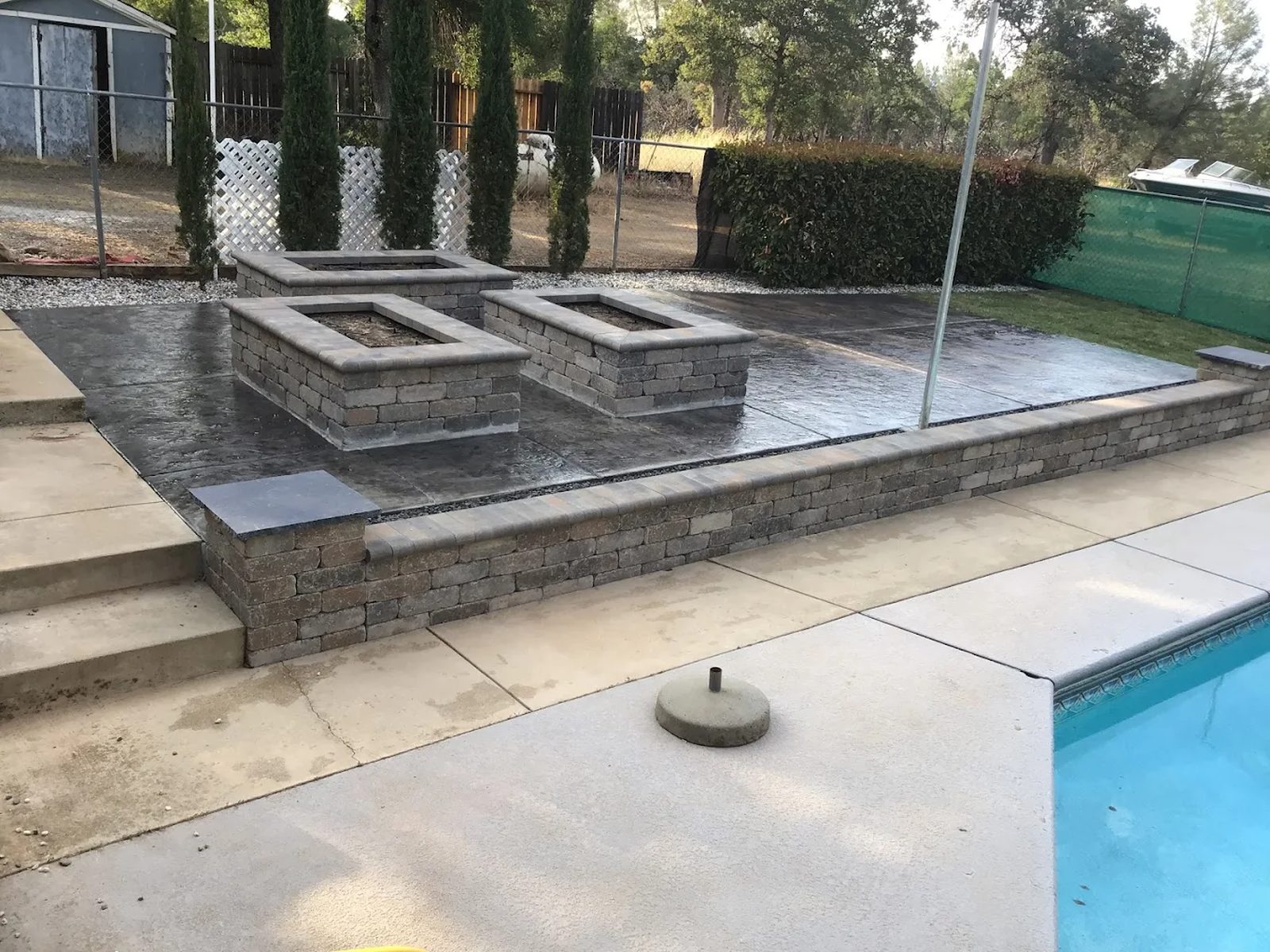 Retaining wall installation in Redding, CA with block walls around patio and raised fire feature area