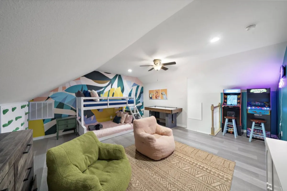 Game loft at Pickle Beach with two arcade machines and a bunk nook