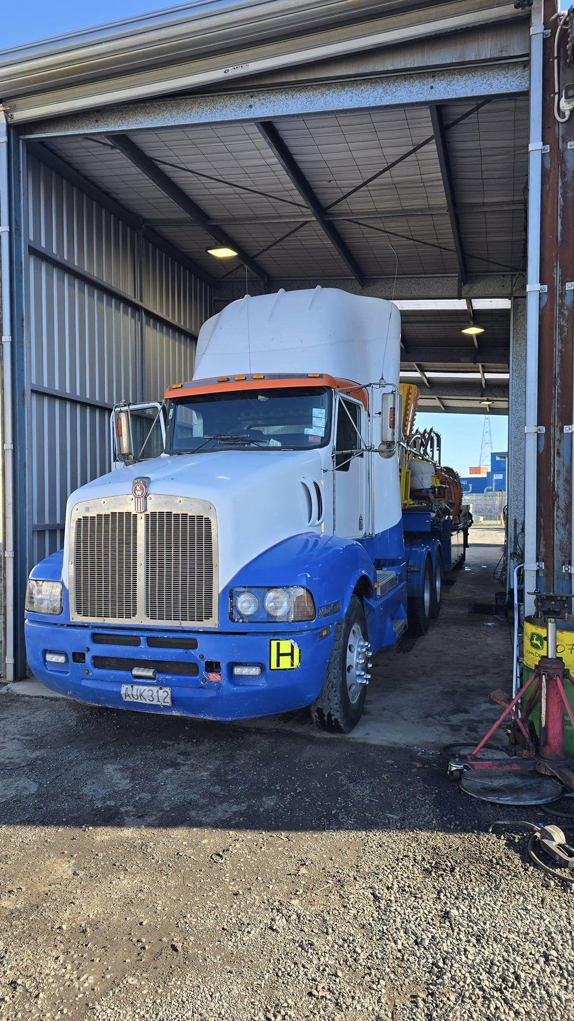 Blue and white heavy diesel truck inside SJS Mechanical & Welding workshop Christchurch