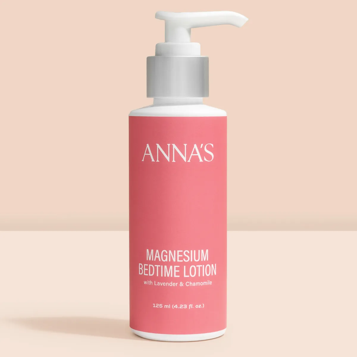 Bottle of Anna's Magnesium Bedtime Lotion set against a peachy background, showcasing its calming packaging.