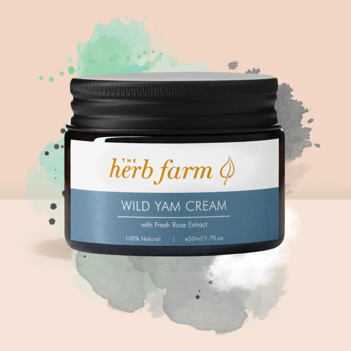 The Herb Farm Wild Yam Cream jar placed against a peachy background, accentuated by splashes of colorful paint for a vibrant look.