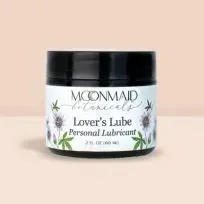 MoonMaid Men's Wild Yam Cream UK jar displayed against a peachy background, enhanced with dynamic splashes of paint for a lively effect.