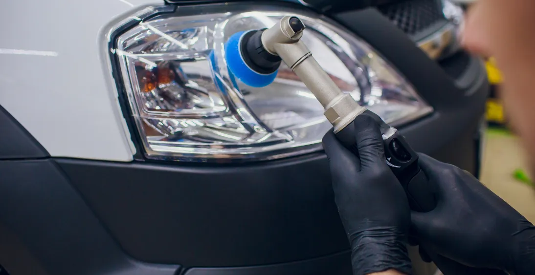 Using small buffing tool to clean headlights