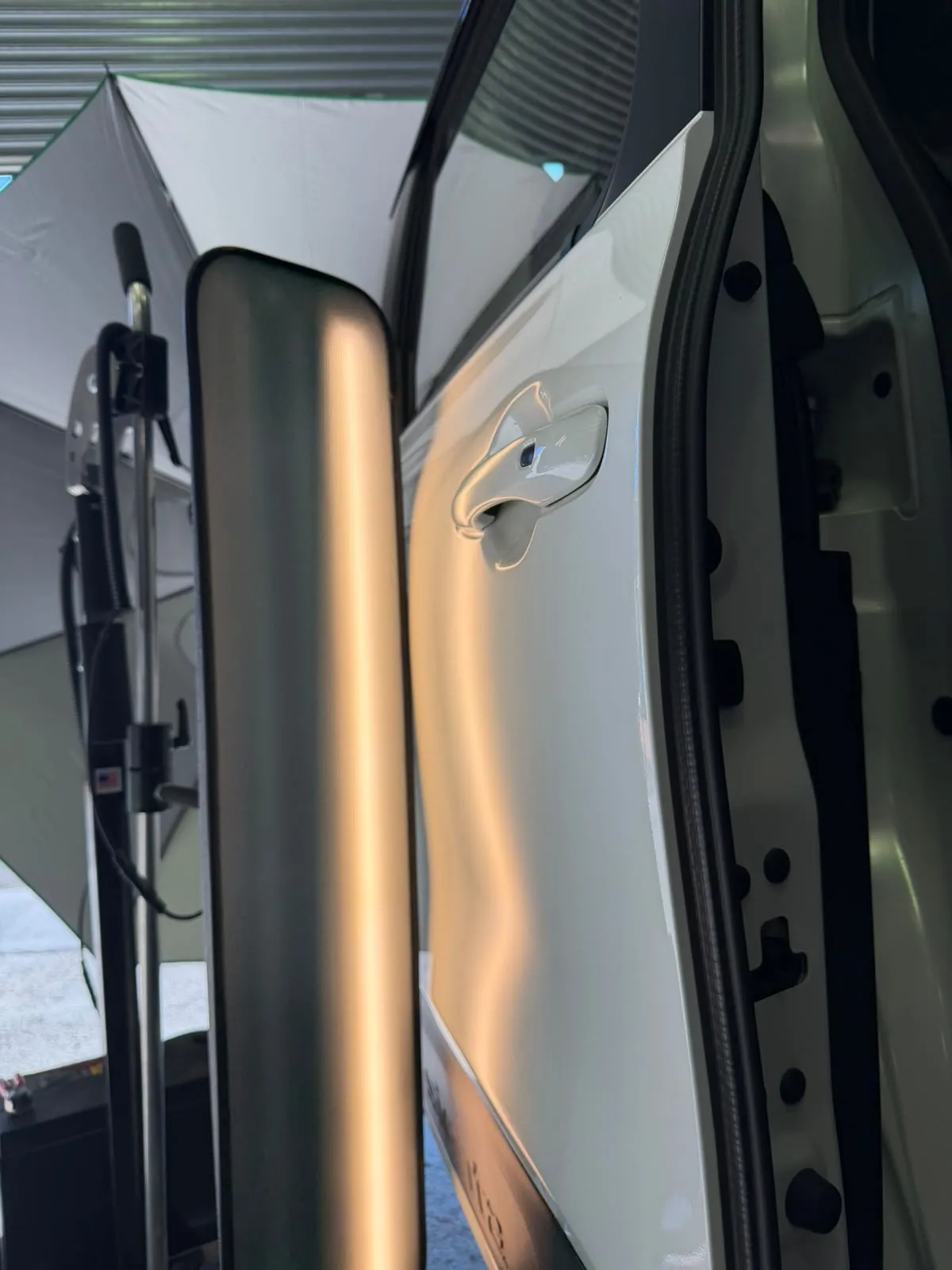 Dent removed on white vehicle with PDR techniques