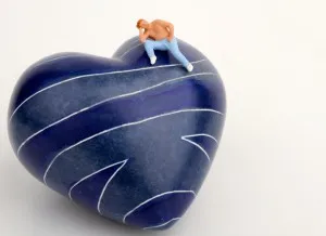 miniatura di uomo solitario su un cuore