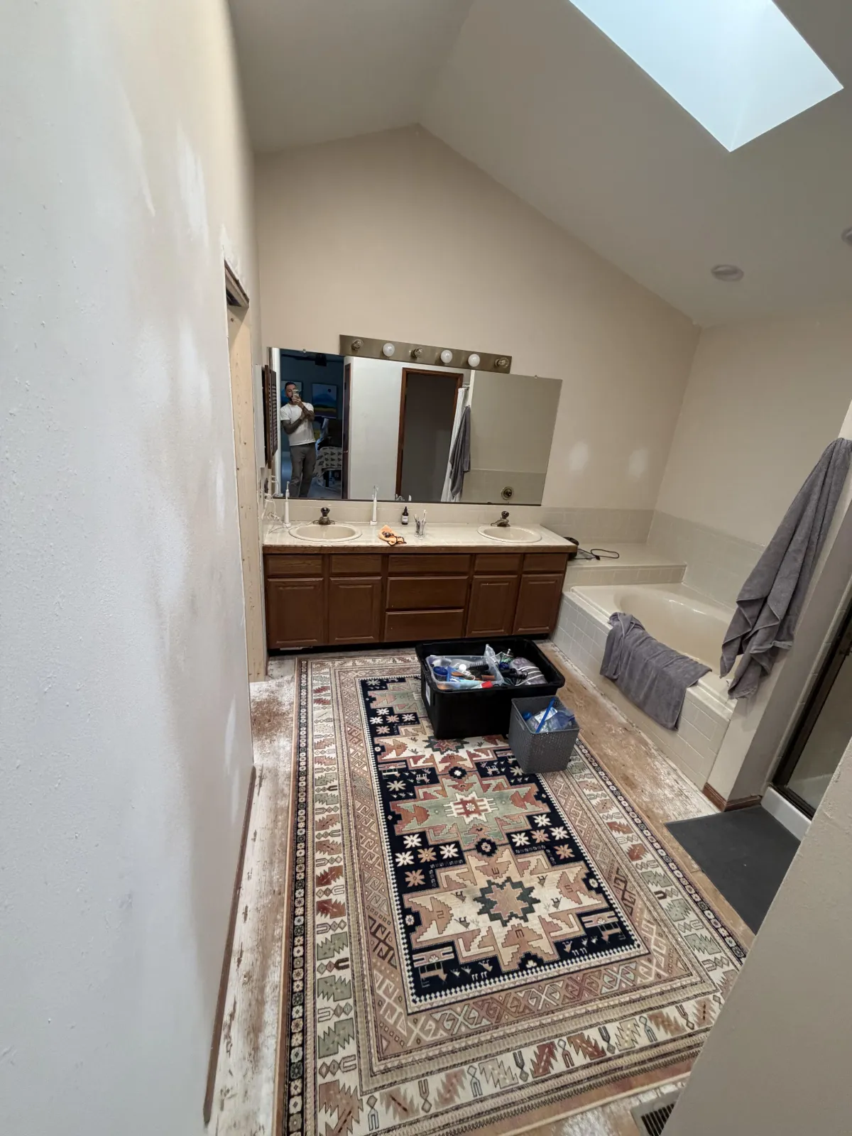 Modern bathroom interior showing a glass shower enclosure with black fixtures and a white vanity sink.