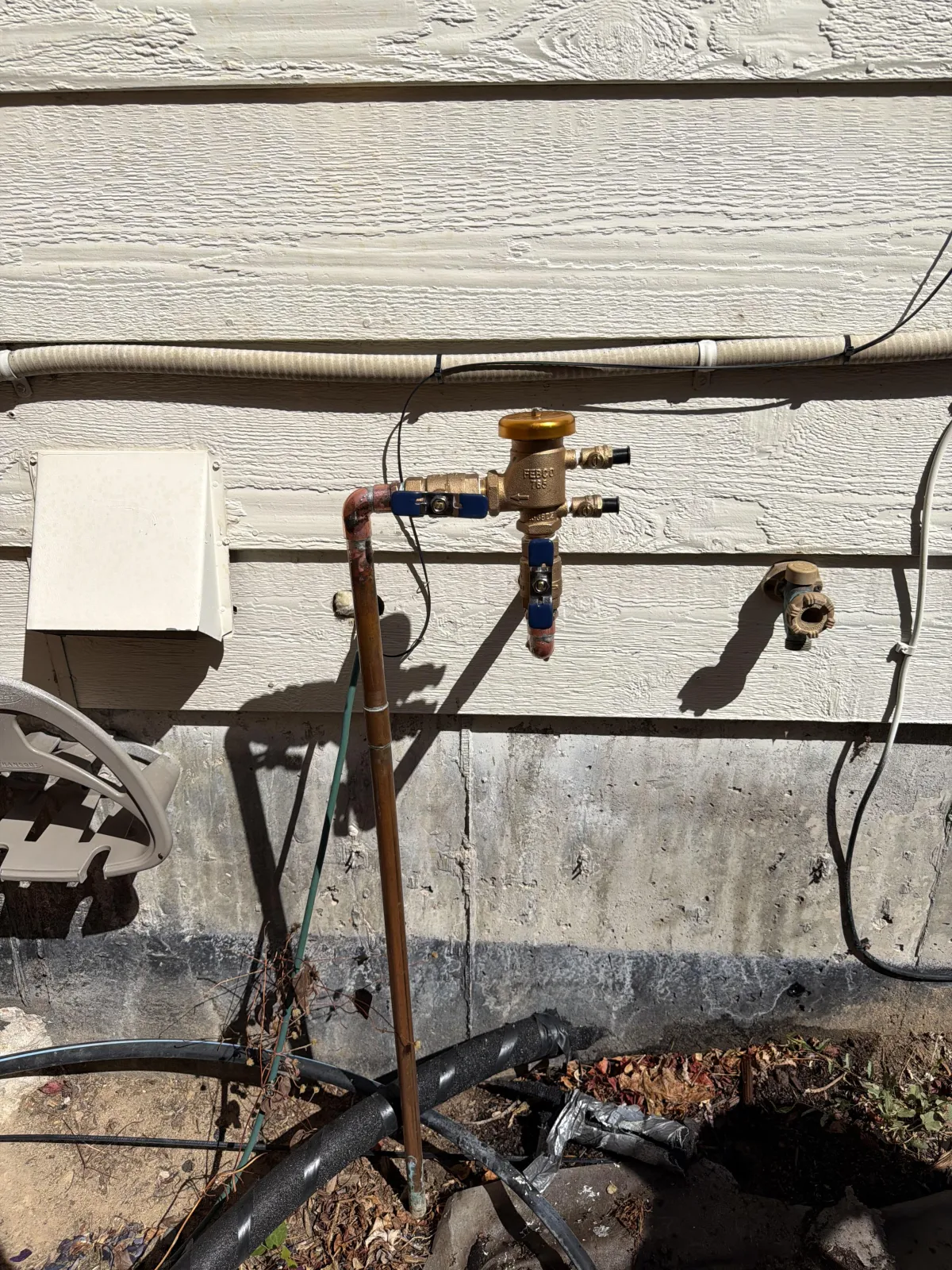Bright, modern bathroom featuring a white freestanding bathtub next to a window, a dark wood vanity with a white top, and two mirrors.