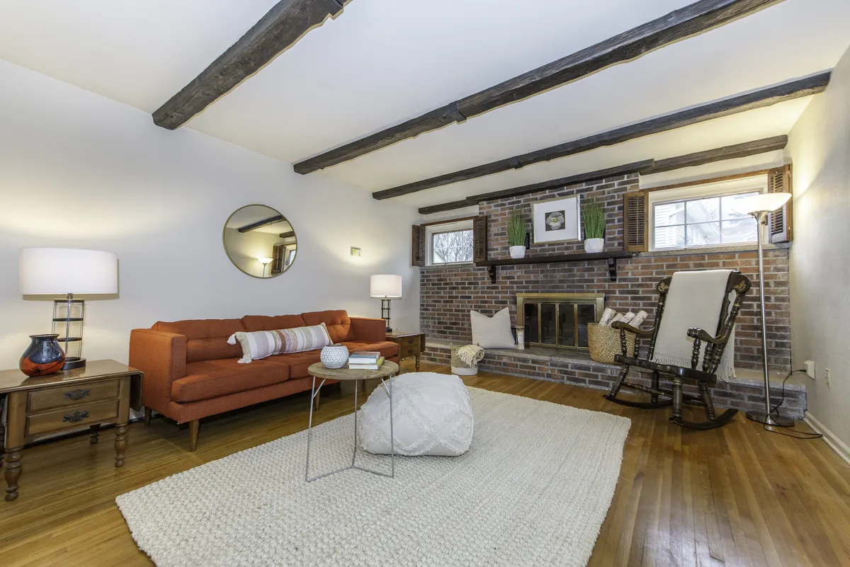 warm living room with brick wood burning fireplace and orange couch