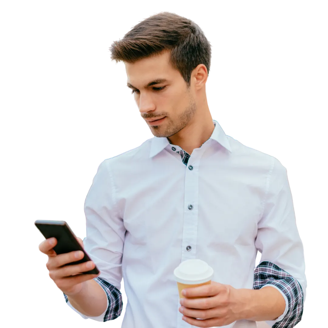 A guy holding a coffee and looking at his phone