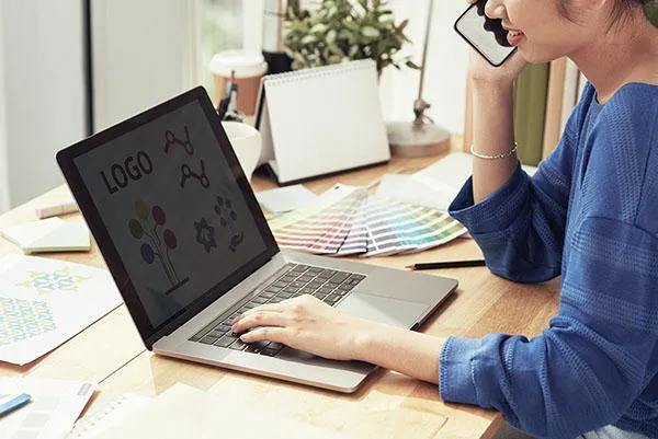 Mujer hablando del logo con el cliente por telefono