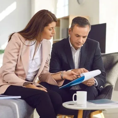 Two business professionals reviewing documents in modern commercial office