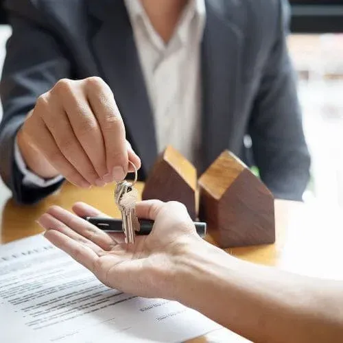 Real estate agent handing house keys to new property owner