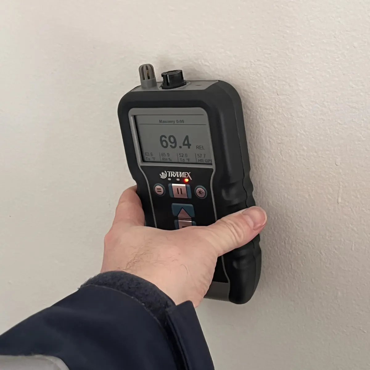 Moisture meter showing high readings during leak detection on interior wall