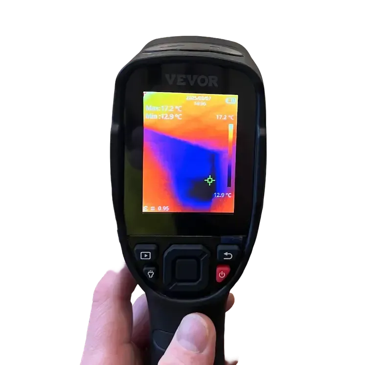 Technician in protective gear inspecting severe mould growth on interior wall with moisture assessment tools