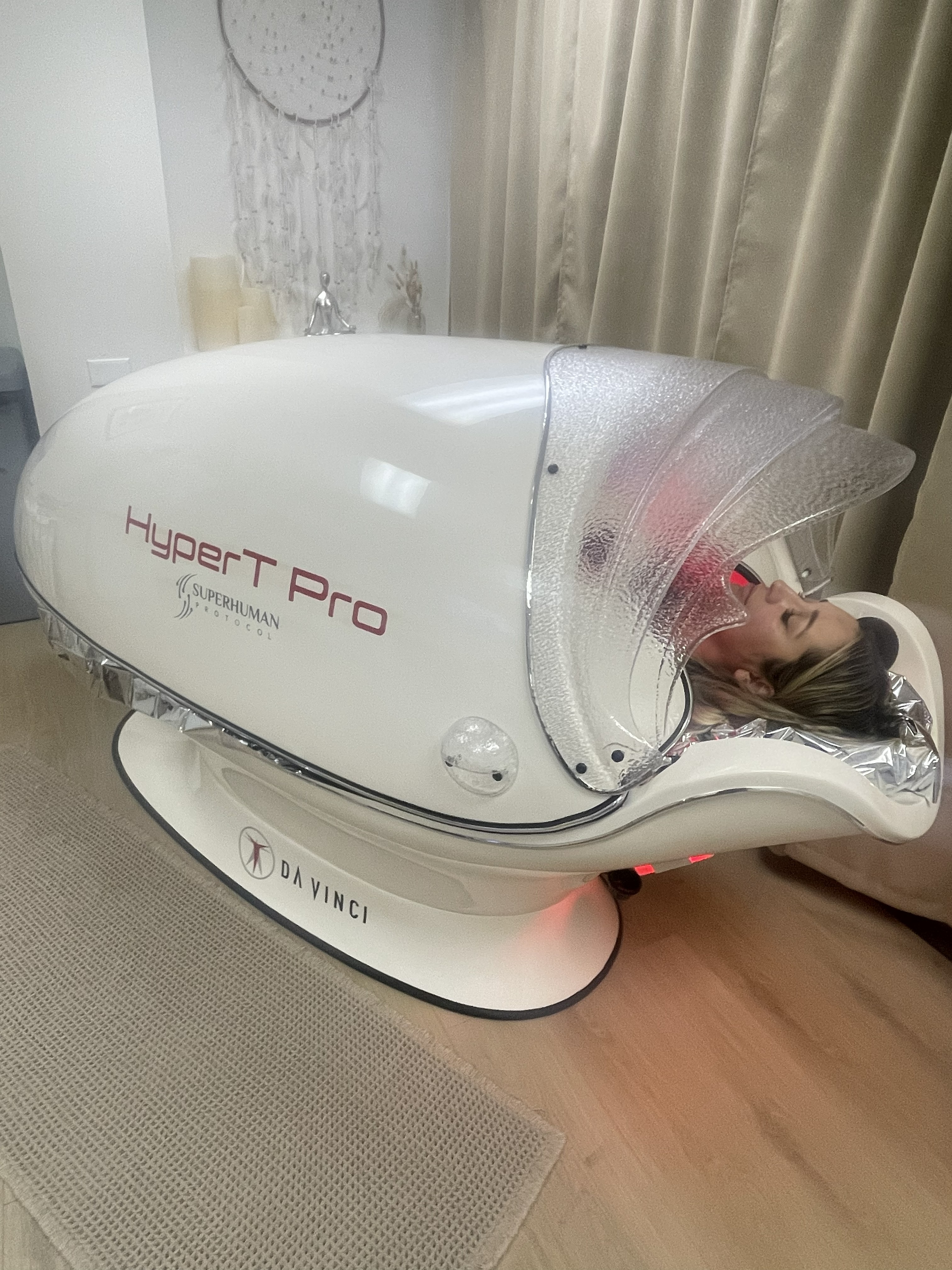 Woman laying in HyperT Pro Infrared Sauna at Khloestika Healing and Wellness Center
