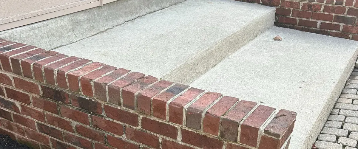 Brick stoop restored after mildew removal with pressure washing