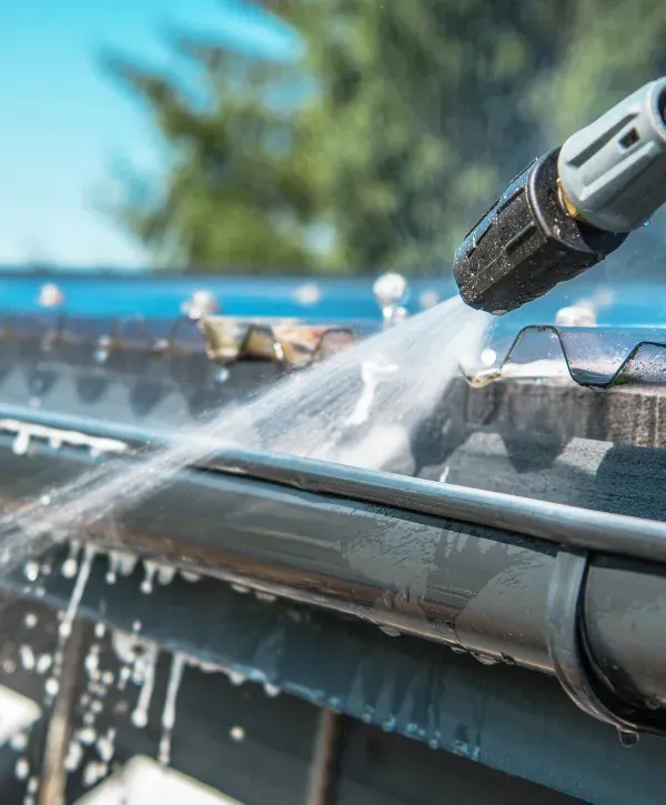 High pressure water jet cleaning metal gutter for home maintenance 