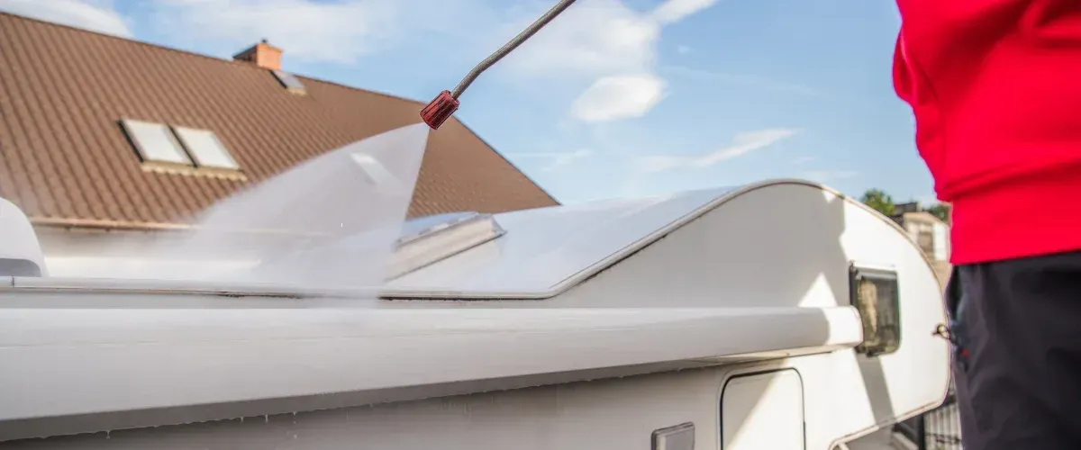 Cleaning RV roof with high-pressure washer removing dirt and grime