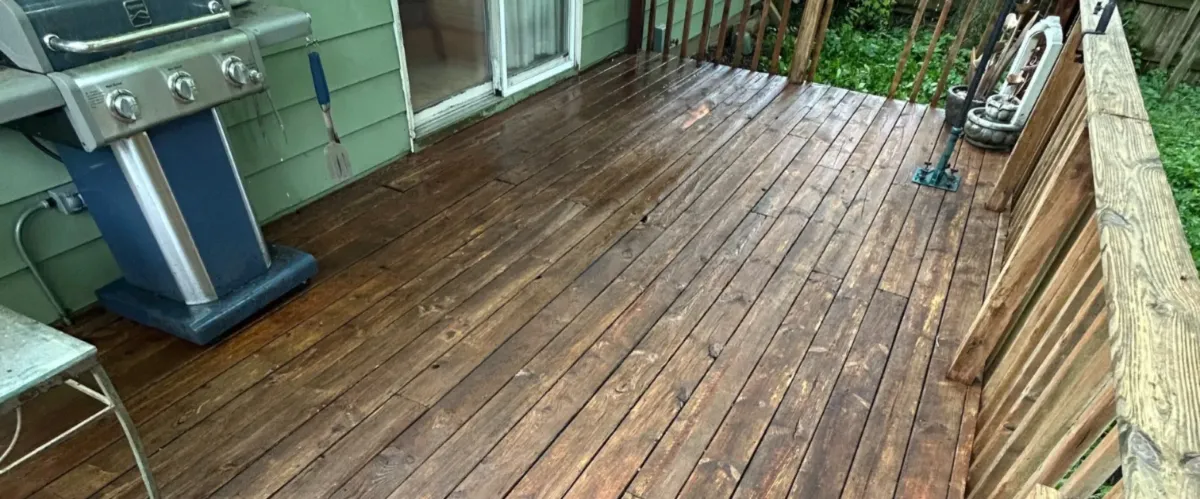 Weathered wooden deck floorboards after rain showing aging and moisture damage
