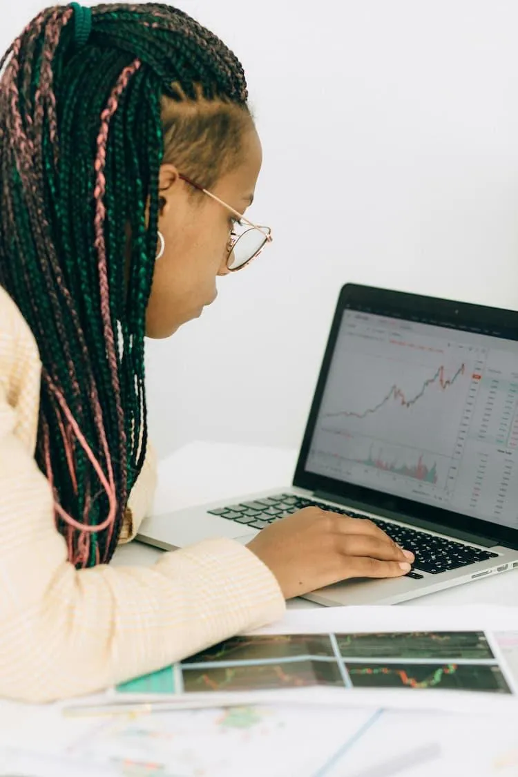 Refugee woman successfully interacts with a laptop showing English and graphs