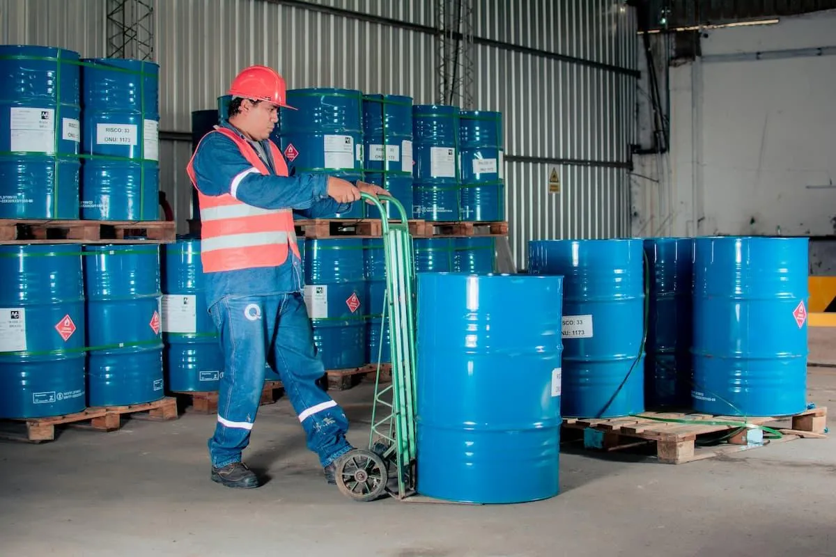 Warehouse worker moves blue containers reflecting workplace success