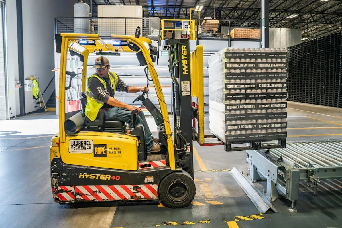 Refugee employee uses a forklift demonstrating successful English Upskilling and Safety Practices