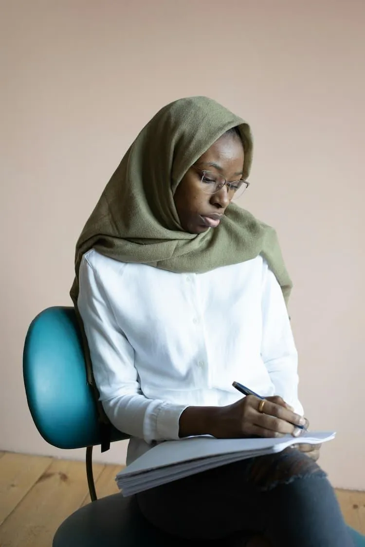 Refugee woman seated reflecting that starting over in life is challenging