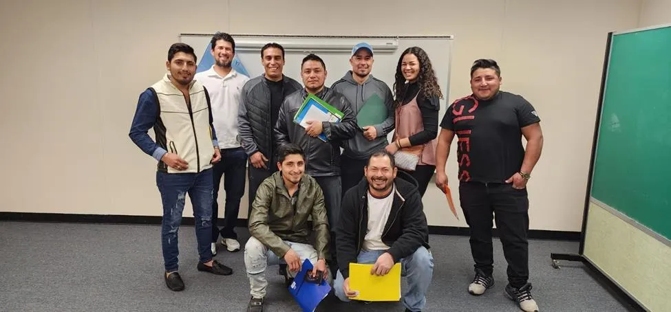 Group of construction workers from Miles Height Masonry pose together after completing the Inmersivo English program