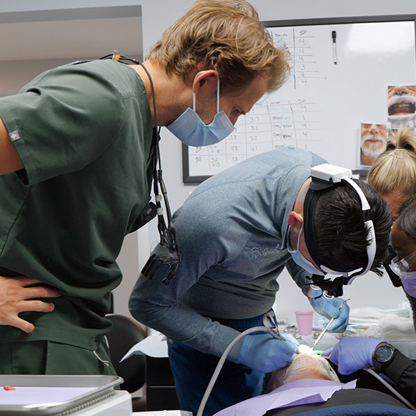 Dentist trainer supervising another dentist
