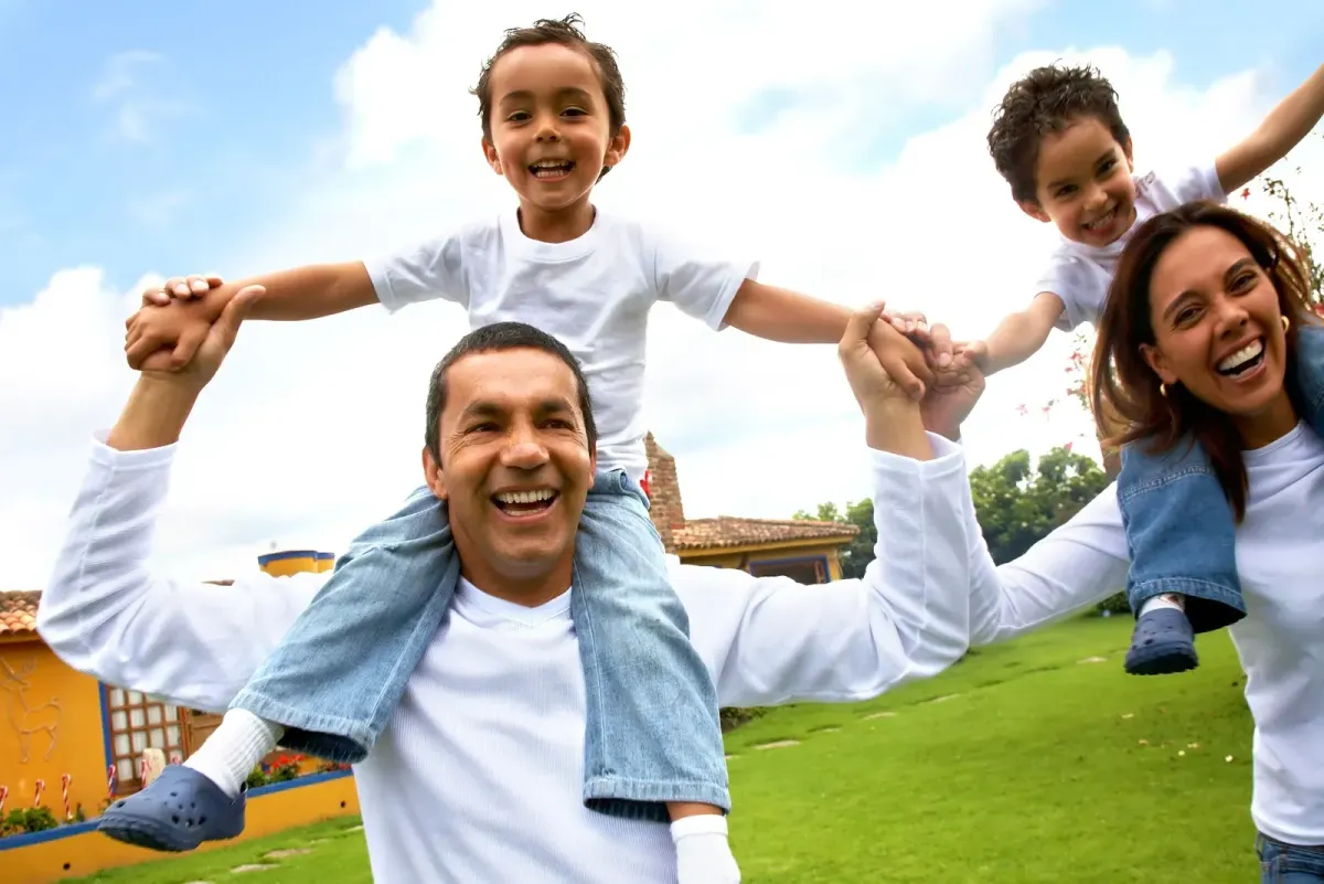 A happy family with parents and children playing outdoors, symbolizing security and stability after winning a product liability case.