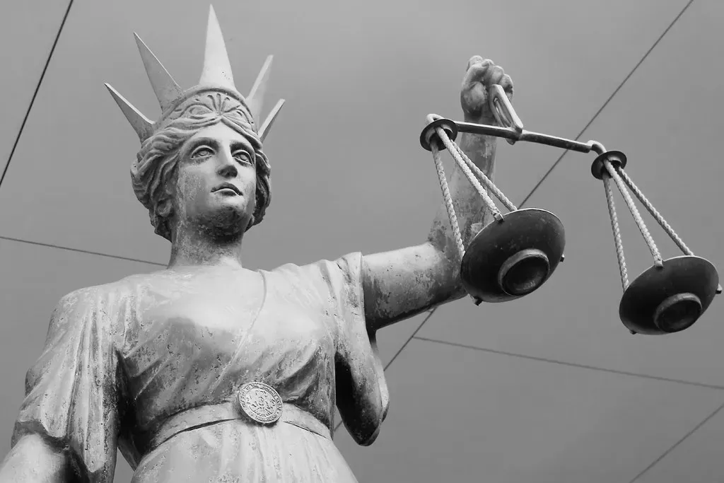 A statue of Lady Justice holding scales, symbolizing accountability and real change for corporate negligence victims.