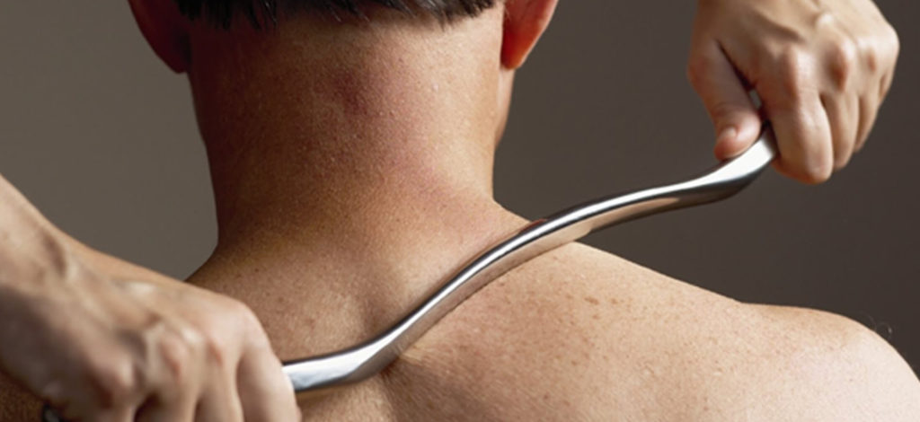 Male patient receiving Graston technique therapy for auto injury recovery at Redmond chiropractic clinic