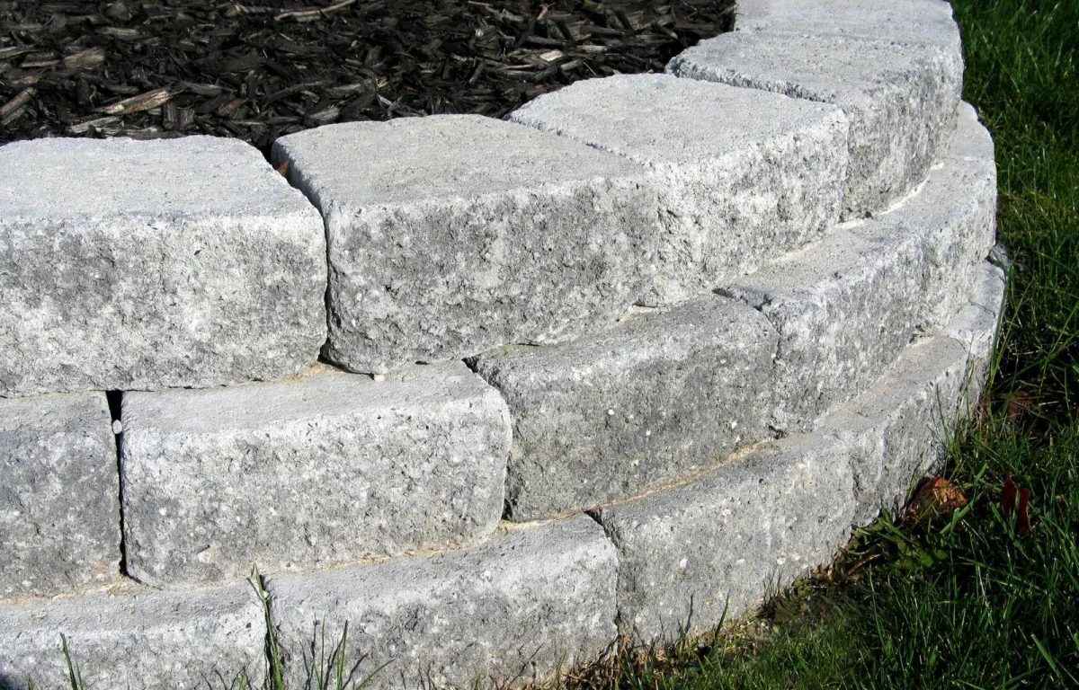 Concrete block retaining wall holding back sloped soil