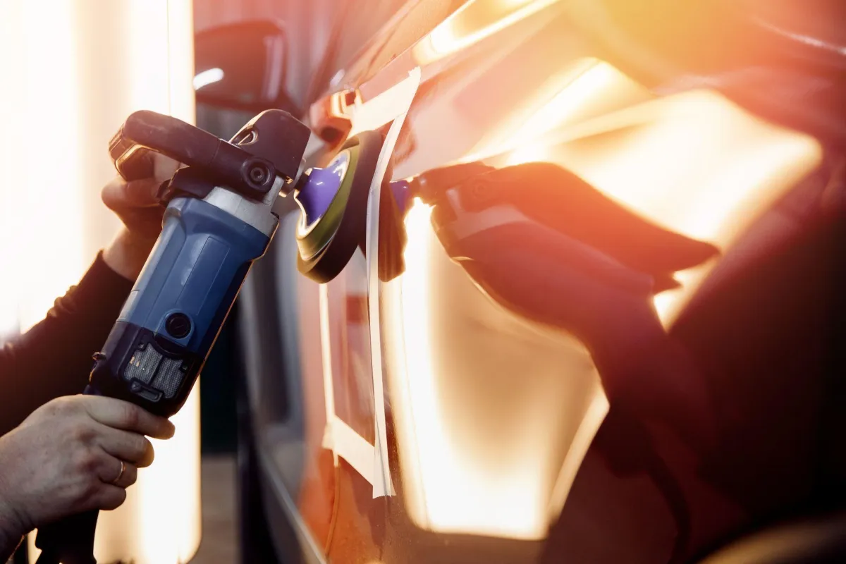 Body shop technician polishing a panel
