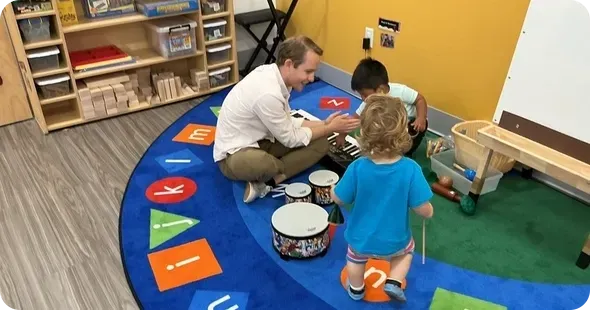 Daycare classroom play activity with toddlers, promoting early childhood development and guided learning