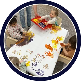 Daycare classroom play activity with toddlers, promoting early childhood development and guided learning