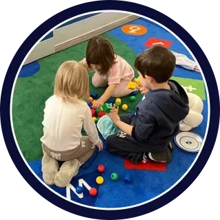 Daycare classroom play activity with toddlers, promoting early childhood development and guided learning