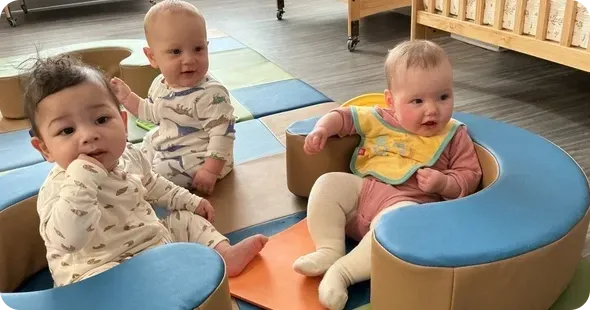 Daycare classroom play activity with toddlers, promoting early childhood development and guided learning