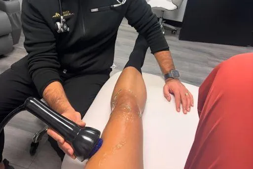 Client receiving OmniWave therapy to reduce muscle pain and improve mobility