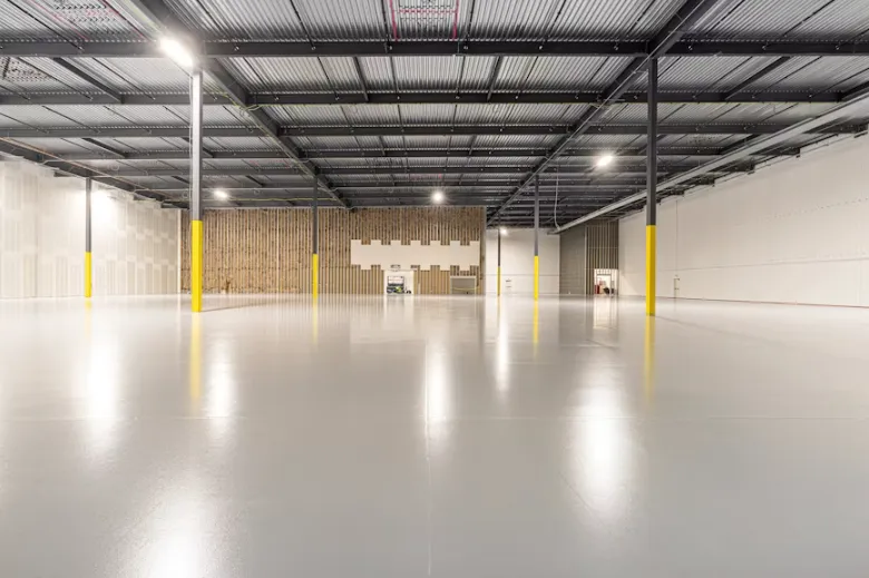 Large commercial warehouse with glossy gray epoxy floor by Epoxy Flooring Service in Albury, NSW, for durable daily use.